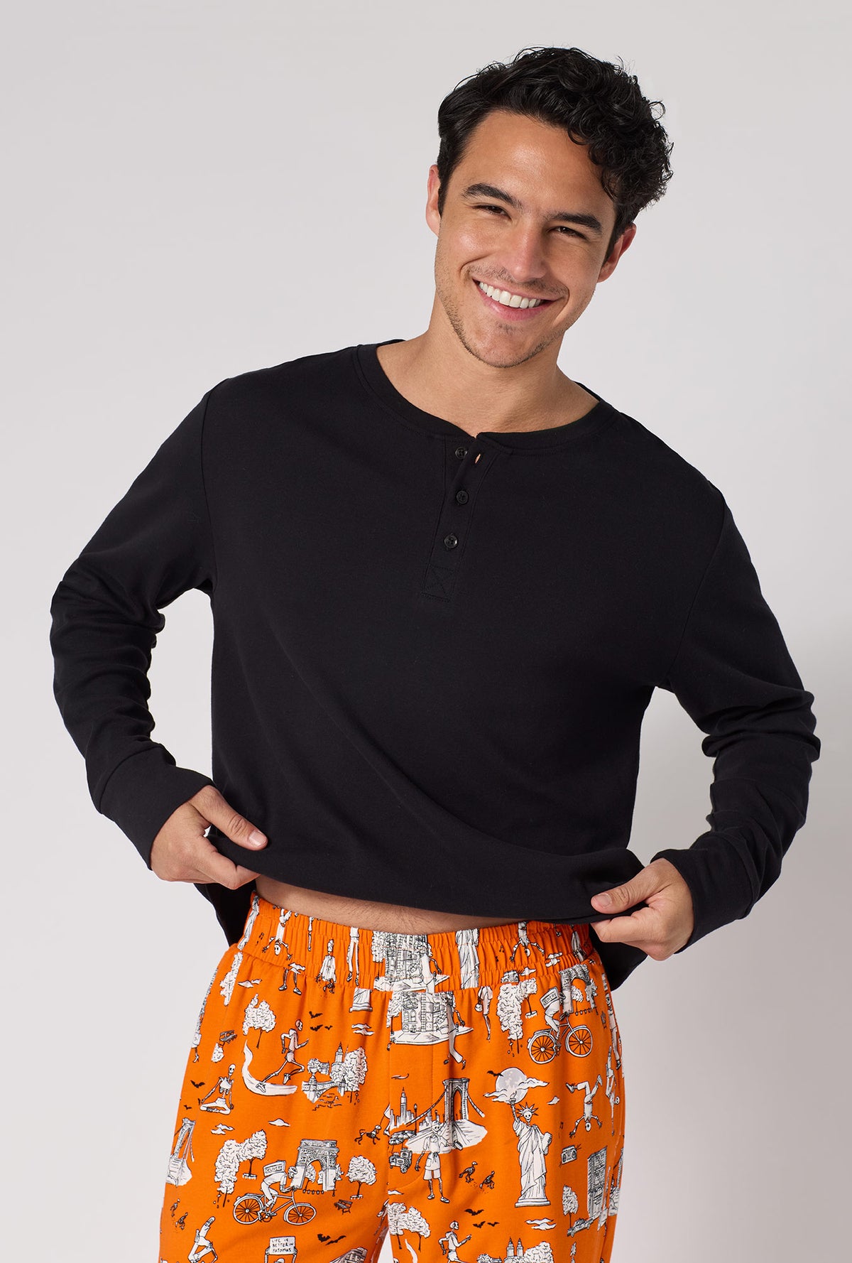 A Man Wearing Orange Spooky In The City Men's Long Sleeve Henley And Jogger Stretch Jersey Pj Set in a close up front view pose