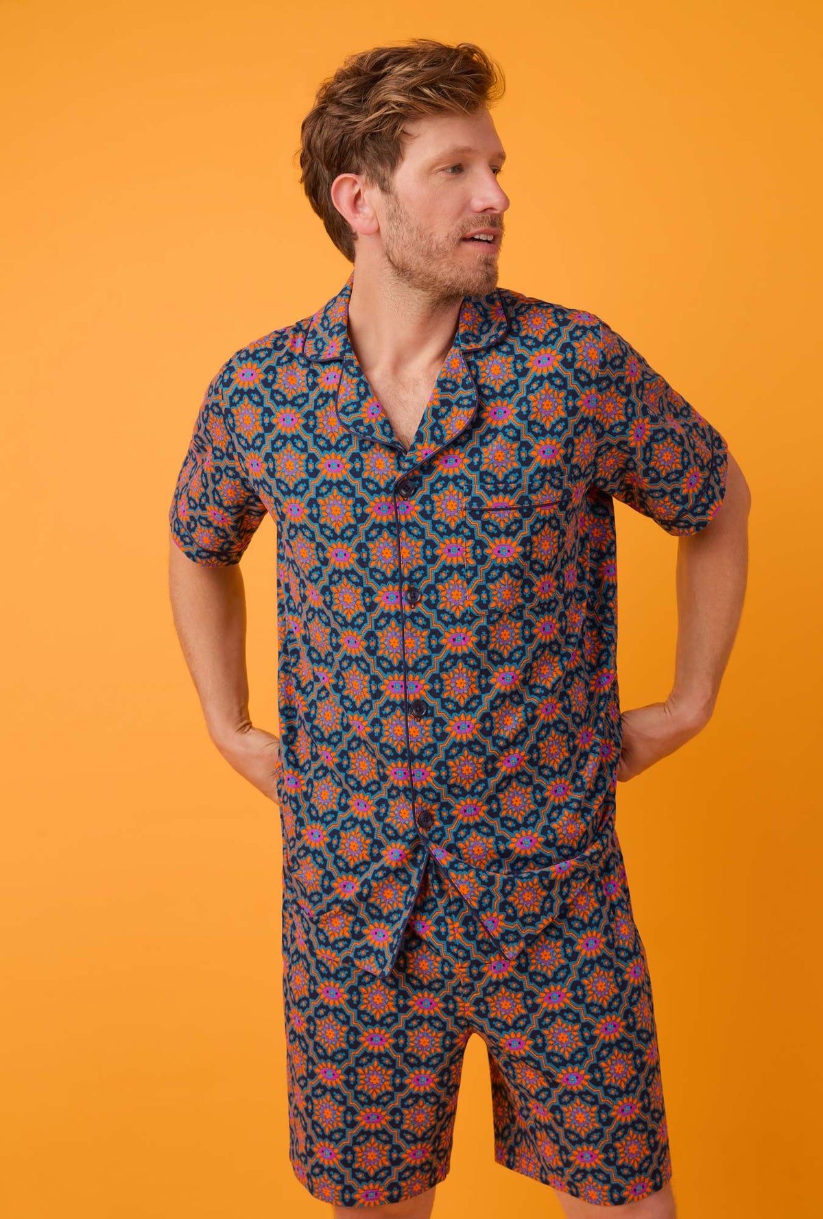 A man wearing short sleeve notch stretch jersey short pj set with navy royal foulard print