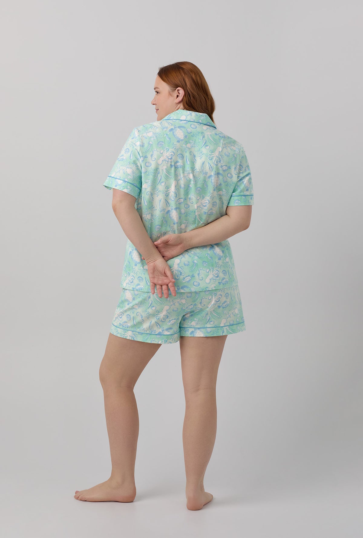 A lady wearing white short sleeve classic shorty stretch jerset plus size pj set with aquatic life print