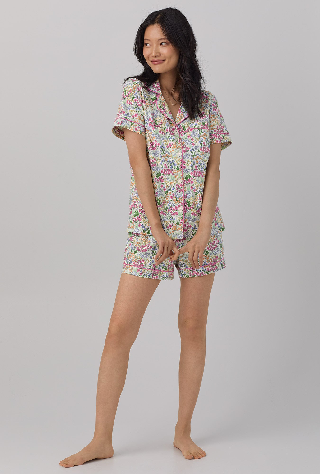 A lady wearing multi color short sleeve classic shorty stretch jersey pj set with cottage garden print.