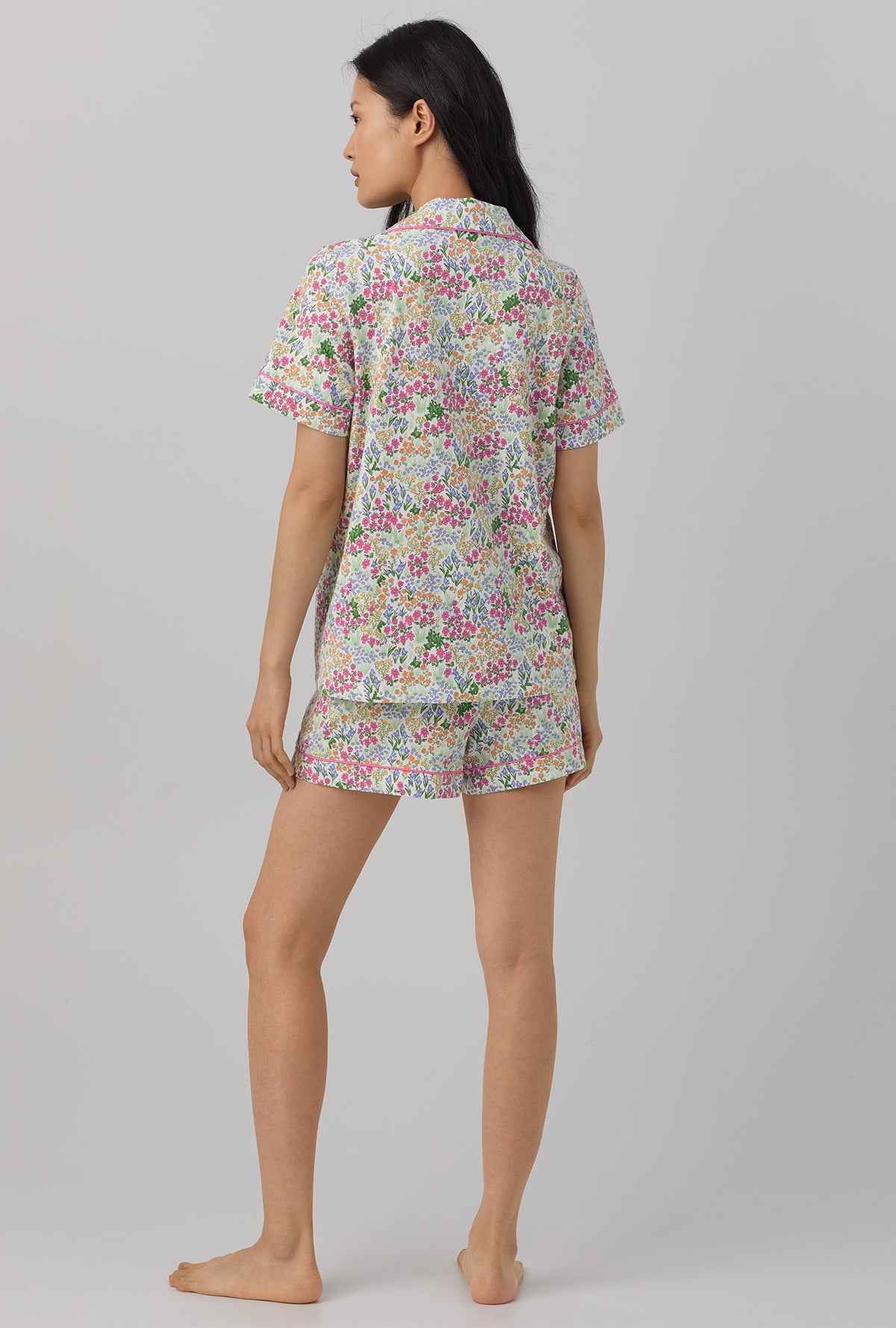 A lady wearing multi color short sleeve classic shorty stretch jersey pj set with cottage garden print.