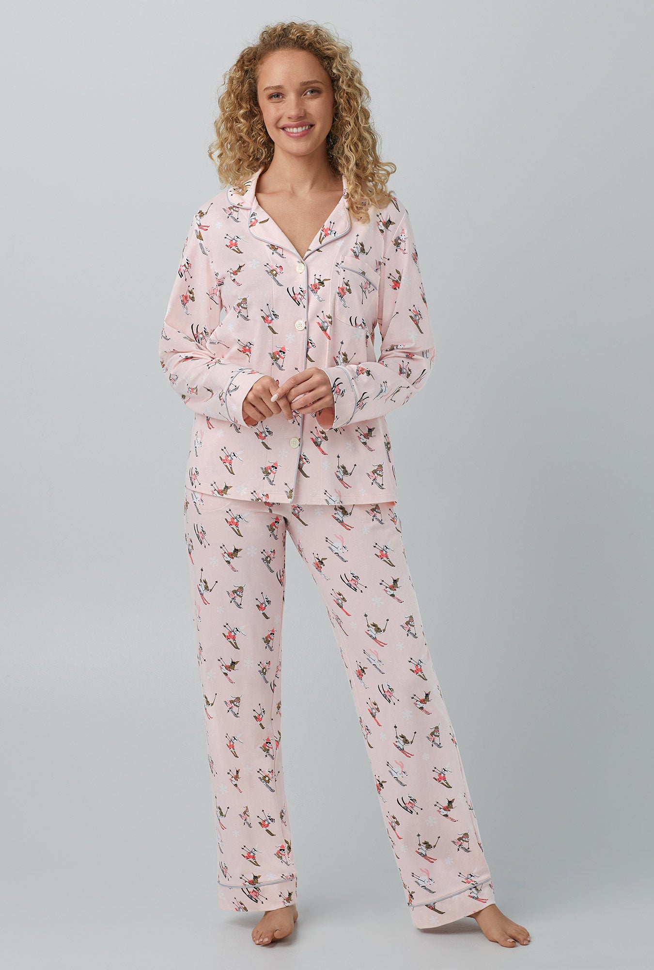 A lady wearing pink long sleeve classic stretch jersey pj set with ski bunnies print.