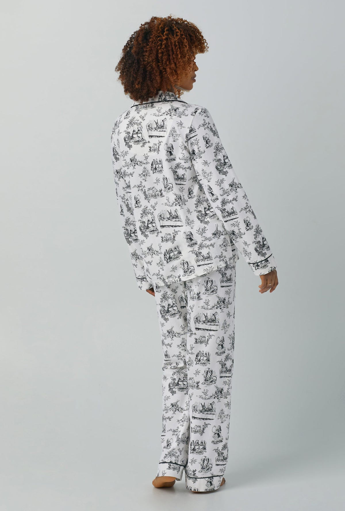 A lady wearing white Long Sleeve Classic Stretch Jersey PJ Set with Adventures in Wonderland print