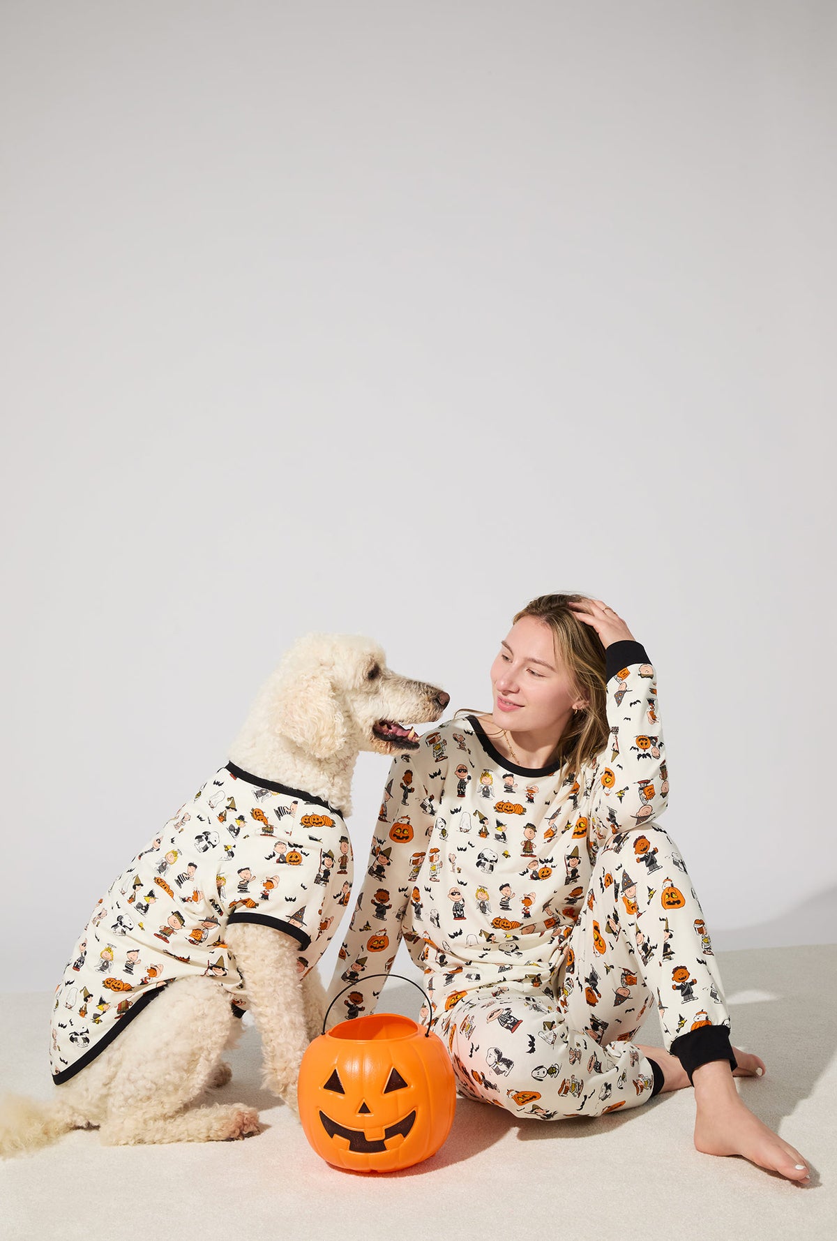 A dog wearing Peanuts® Snoopy&#39;s Halloween Stretch Jersey Dog Pajama