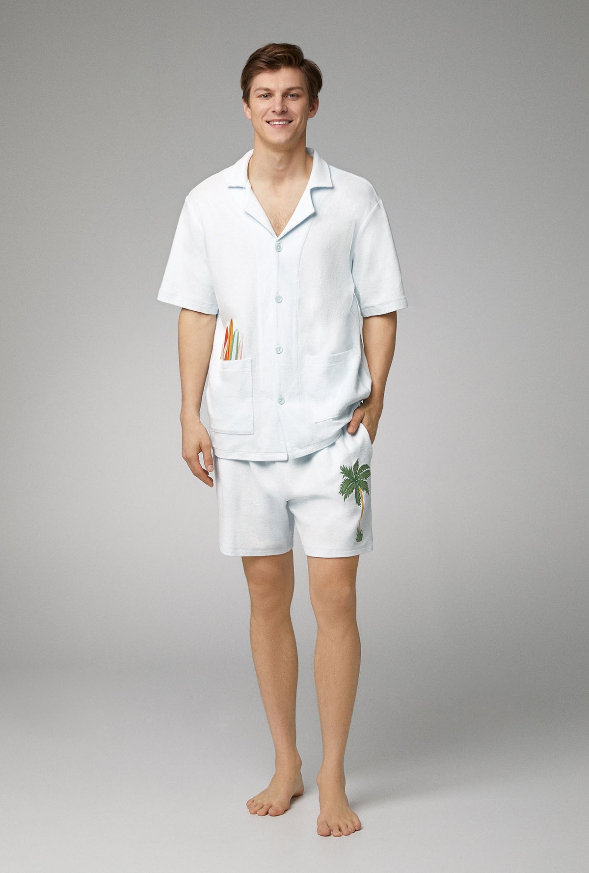 A man wearing white short sleeve notch woven cotton baby loop terry boxer pj set with country air print.