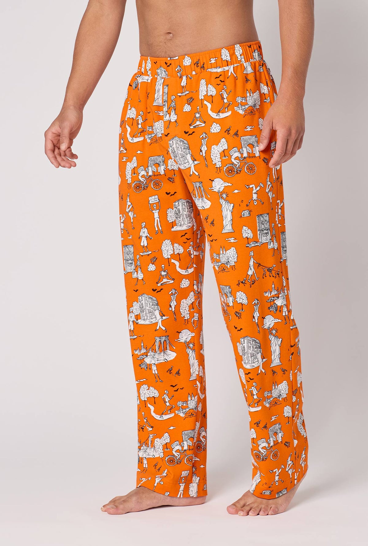 A Man Wearing Orange Spooky In The City Men's Stretch Jersey Pj Pant in a side angled pose