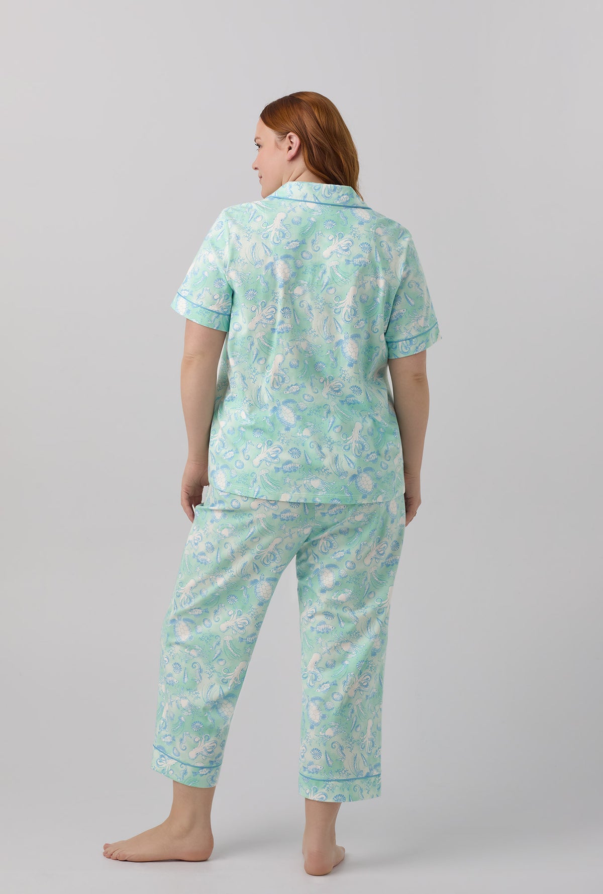 A lady wearing short sleeve stretch jersey cropped plus size pj set with aquatic life print