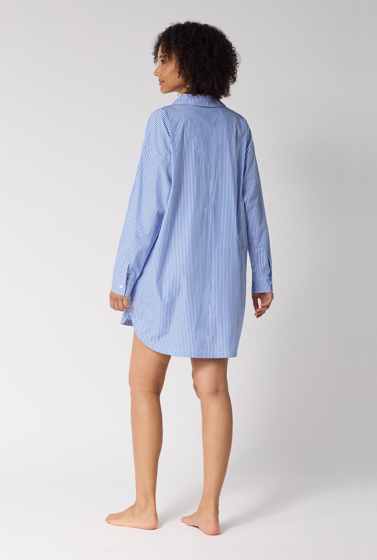 A Lady Wearing French Stripe High Low Woven Supersoft Cotton Poplin Boyfriend Shirt in a back view pose