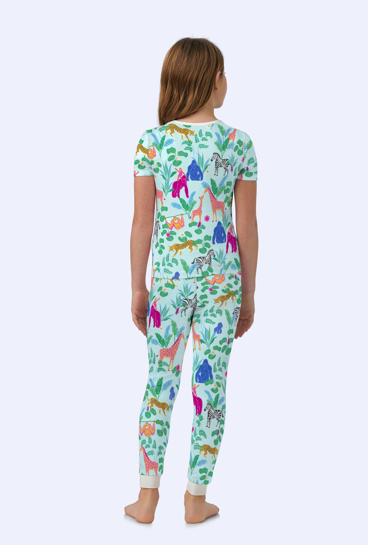 A girl wearing short sleeve stretch jersey pj set with addos birthday bash print