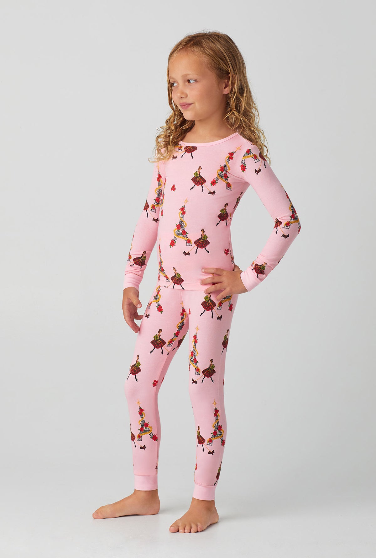 A girl wearing pink long sleeve stretch jersey kids pj set with christmas chic print.