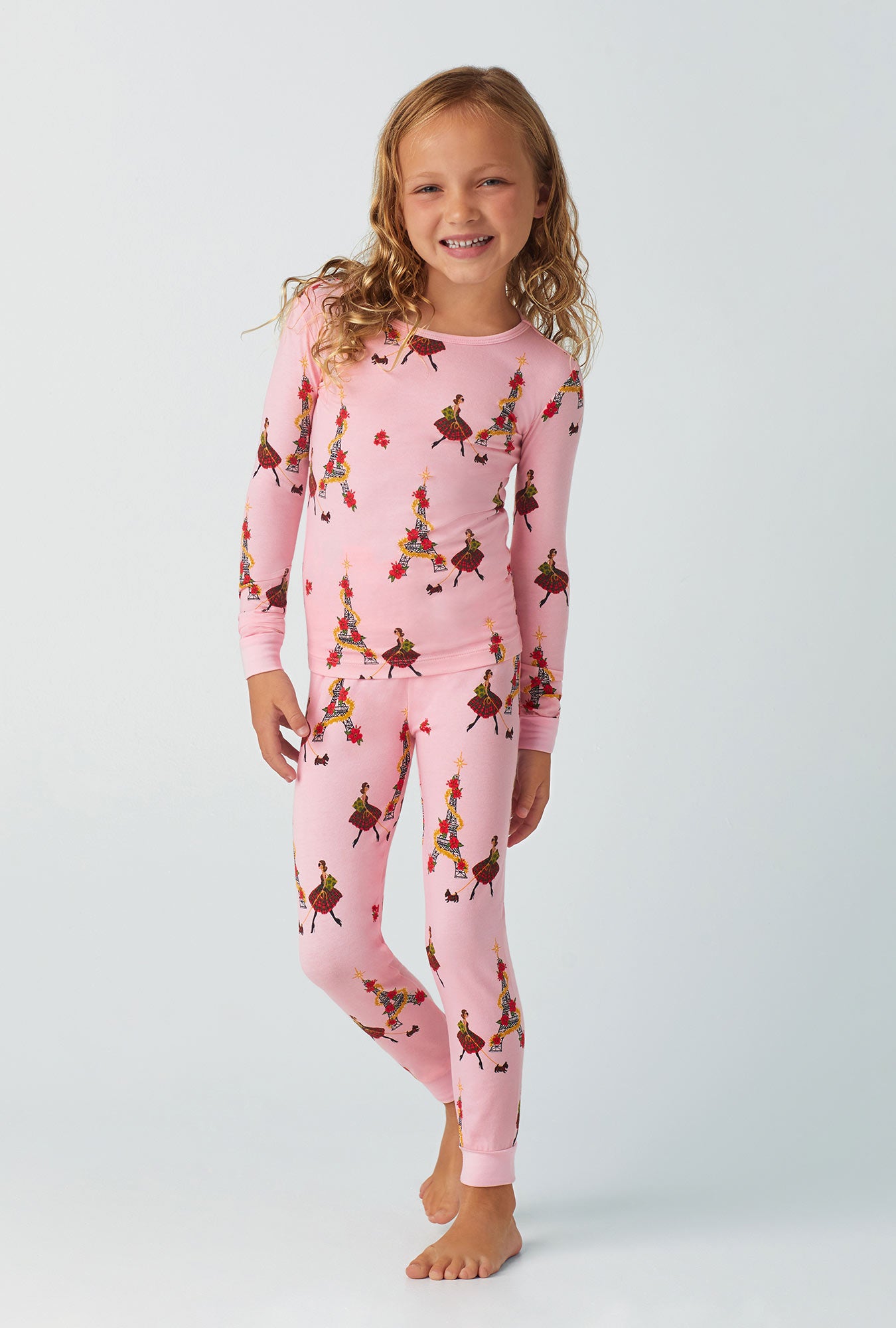 A girl wearing pink long sleeve stretch jersey kids pj set with christmas chic print.