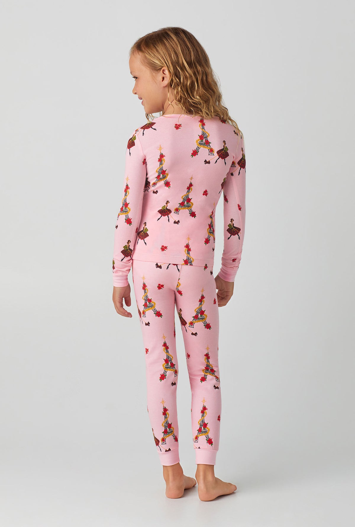 A girl wearing pink long sleeve stretch jersey kids pj set with christmas chic print.