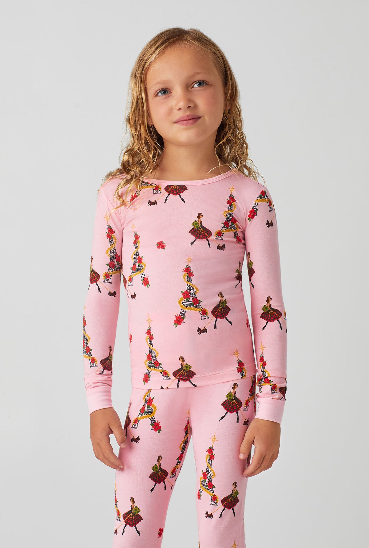 A girl wearing pink long sleeve stretch jersey kids pj set with christmas chic print.