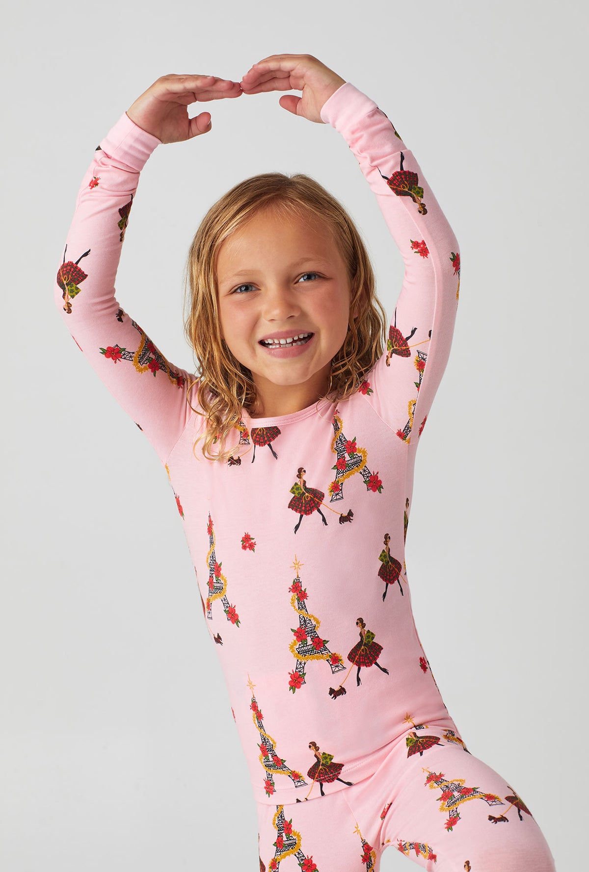 A girl wearing pink long sleeve stretch jersey kids pj set with christmas chic print.