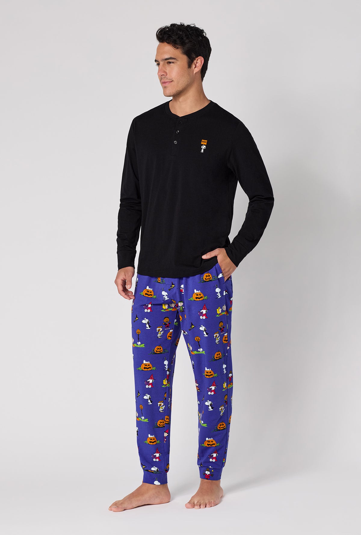 A Man Wearing Spooky Season Snoopy Men's Long Sleeve Henley And Jogger Stretch Jersey Pj Set in a side angled pose