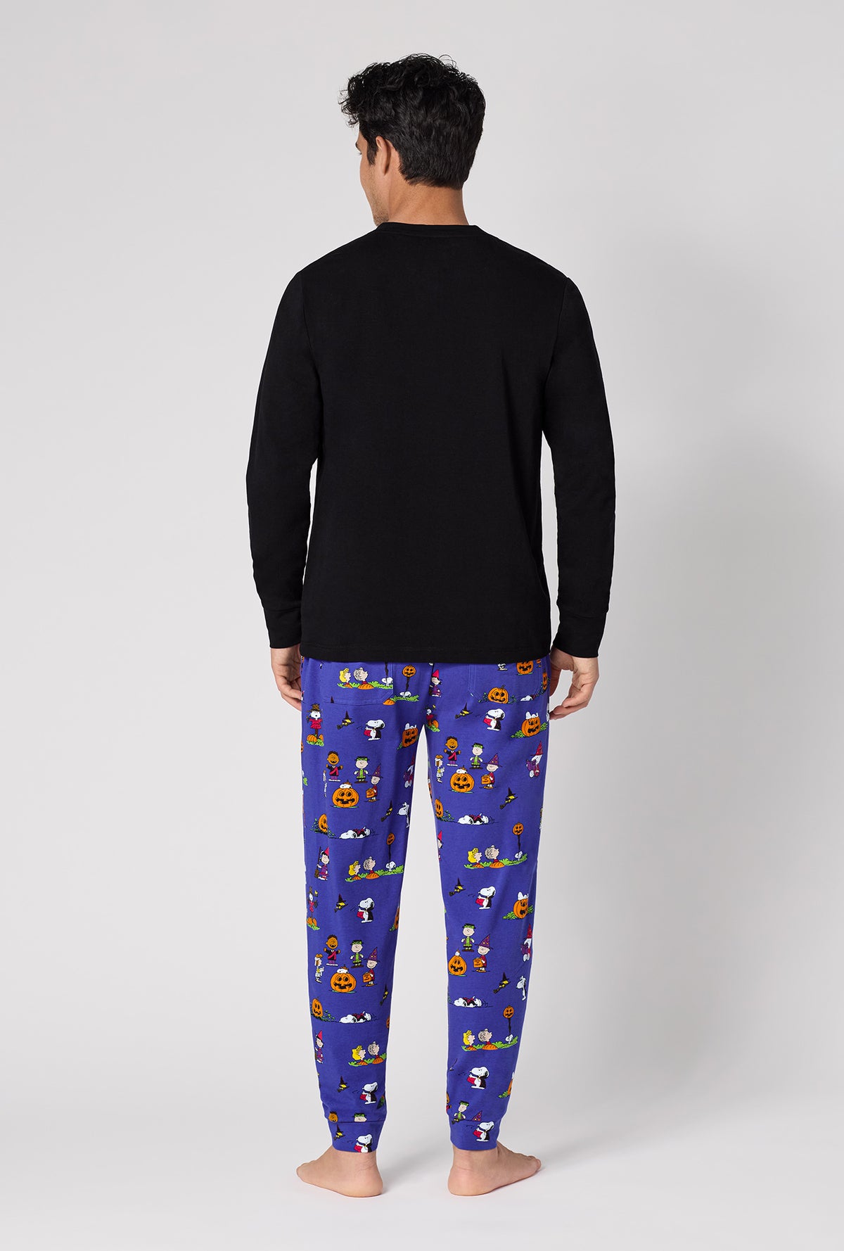 A Man Wearing Spooky Season Snoopy Men's Long Sleeve Henley And Jogger Stretch Jersey Pj Set in a back view pose