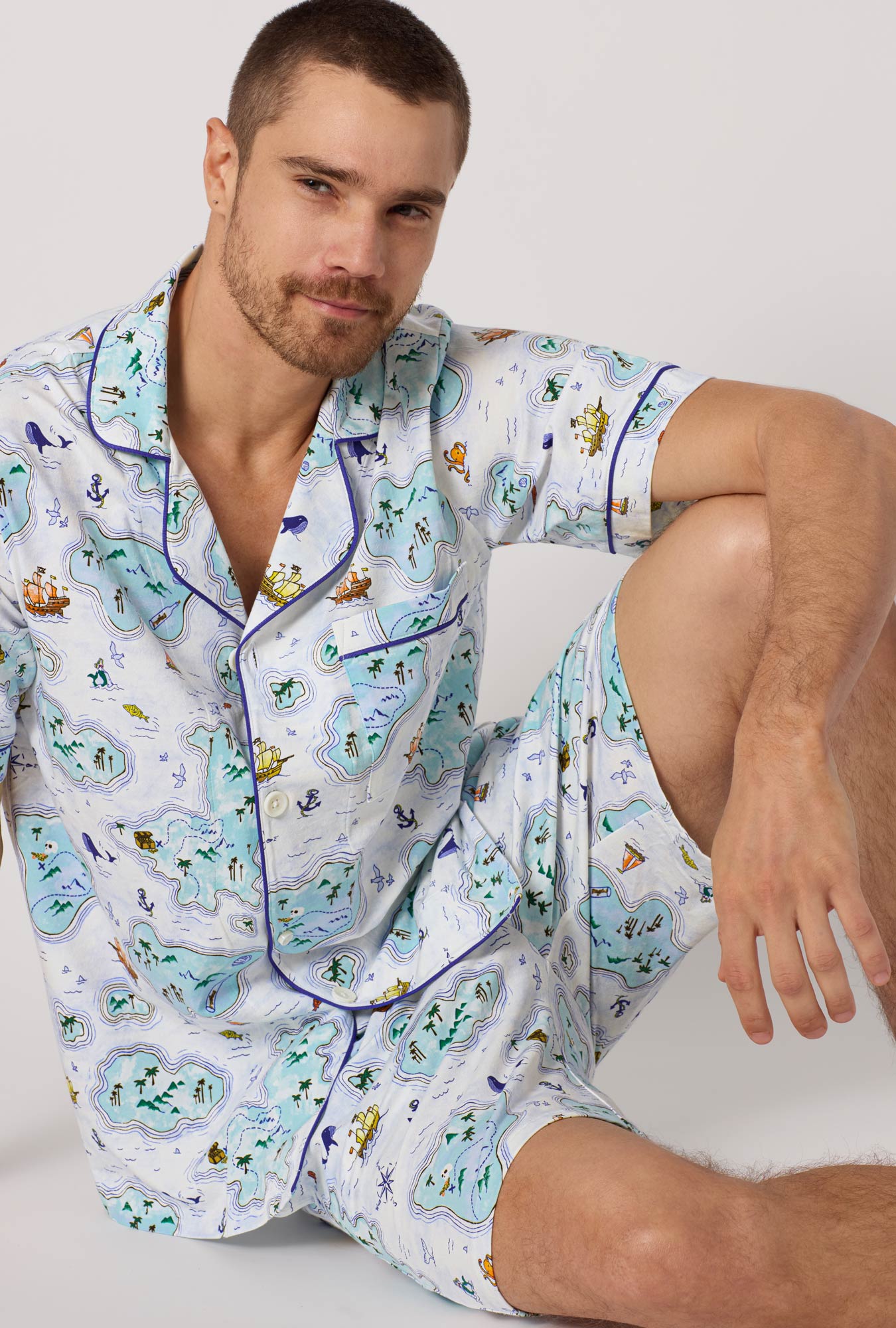 A man wearing Treasure Hunt Men's Short Sleeve Classic Stretch Jersey Short Pj Set closer look sitting on the floor