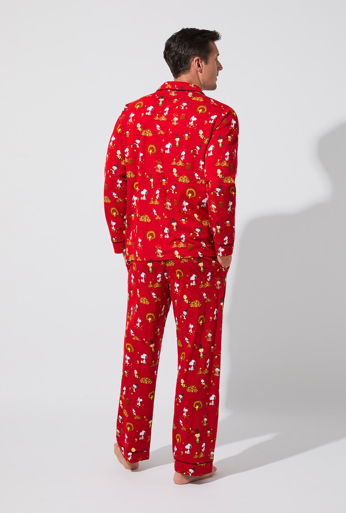 A man wearing Peanuts® Snoopy&#39;s Thanksgiving Mens Long Sleeve Classic Stretch Jersey PJ Set
