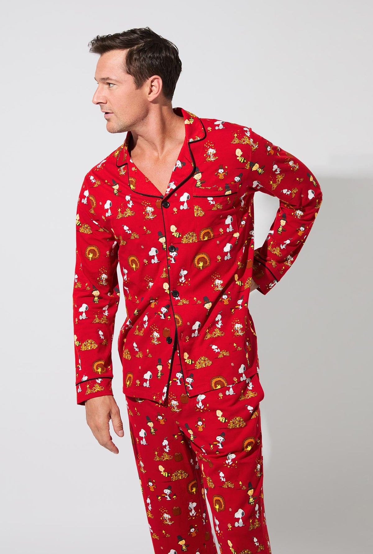 A man wearing Peanuts® Snoopy&#39;s Thanksgiving Mens Long Sleeve Classic Stretch Jersey PJ Set