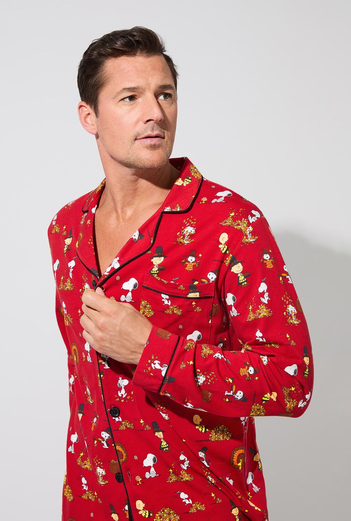A man wearing Peanuts® Snoopy&#39;s Thanksgiving Mens Long Sleeve Classic Stretch Jersey PJ Set