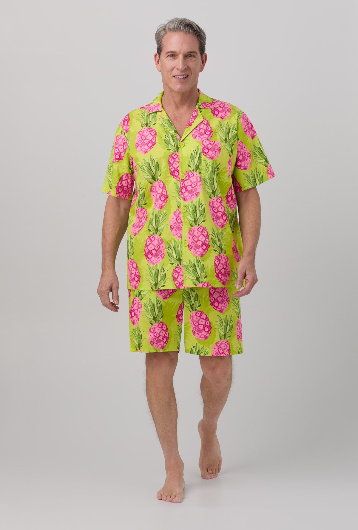 A man wearing short sleeve woven poplin short pj set with kiwi pineapple print