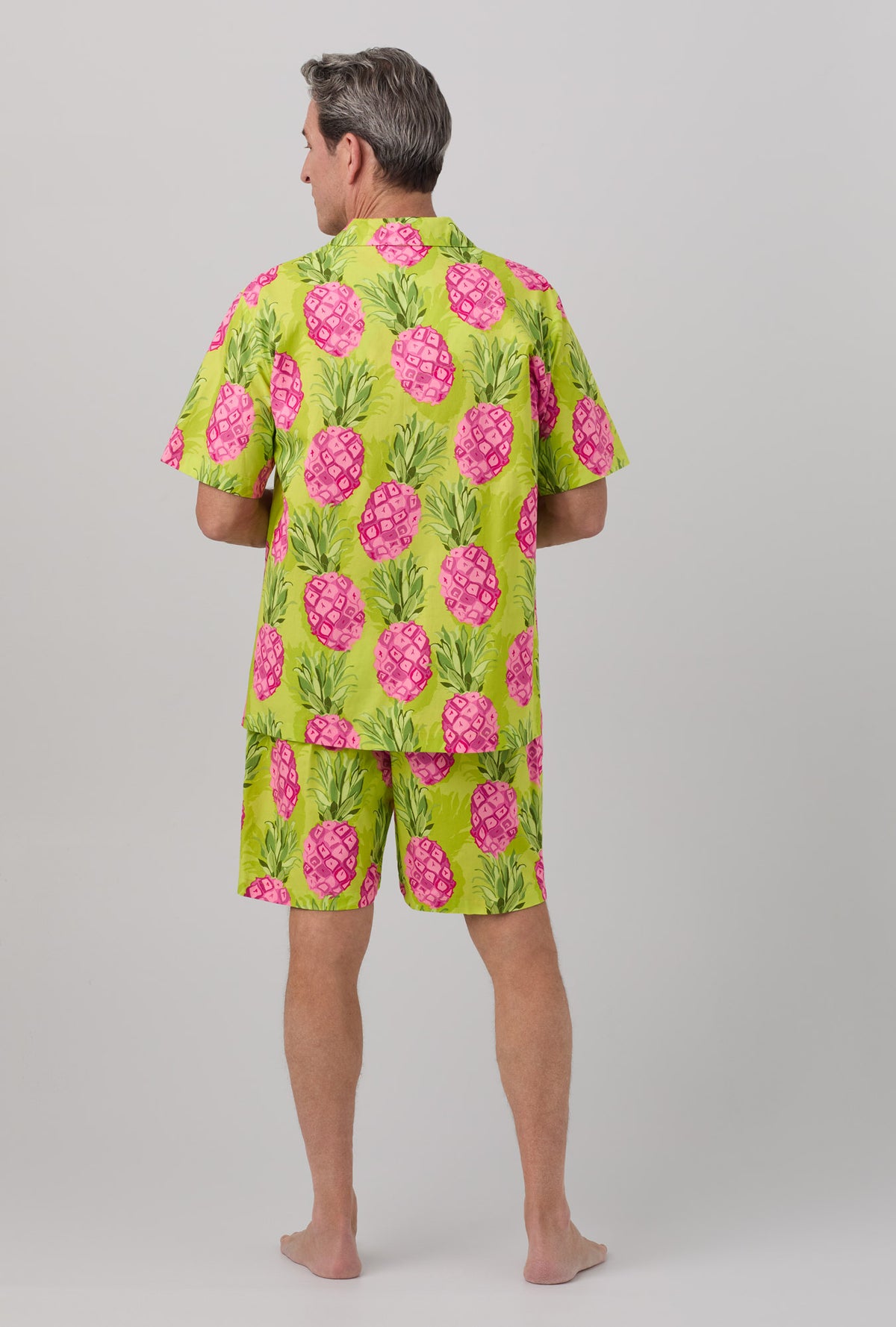A man wearing short sleeve woven poplin short pj set with kiwi pineapple print