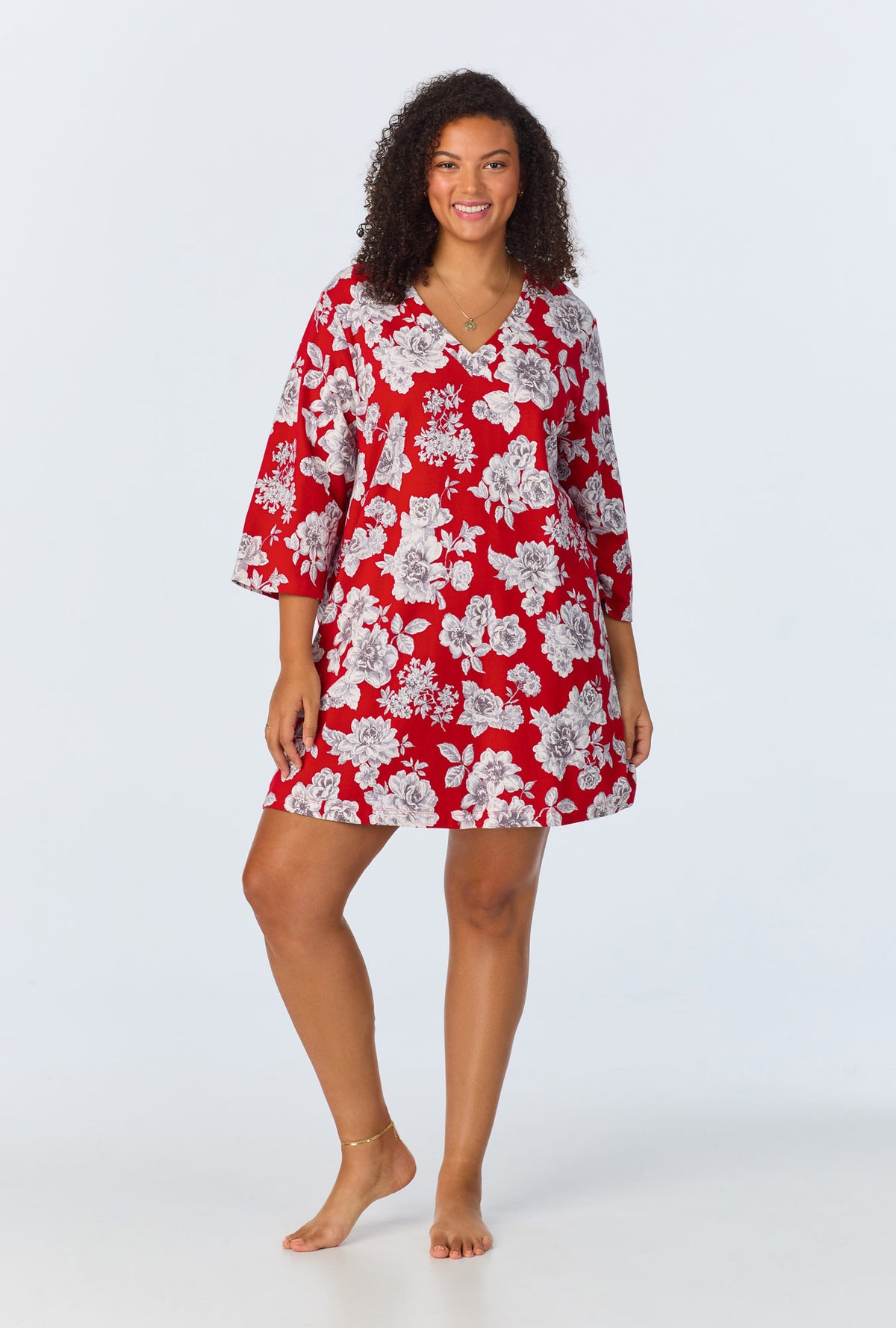 A lady wearing red quarter sleeve  stretch jersey plus size sleepshirt with camellias print.