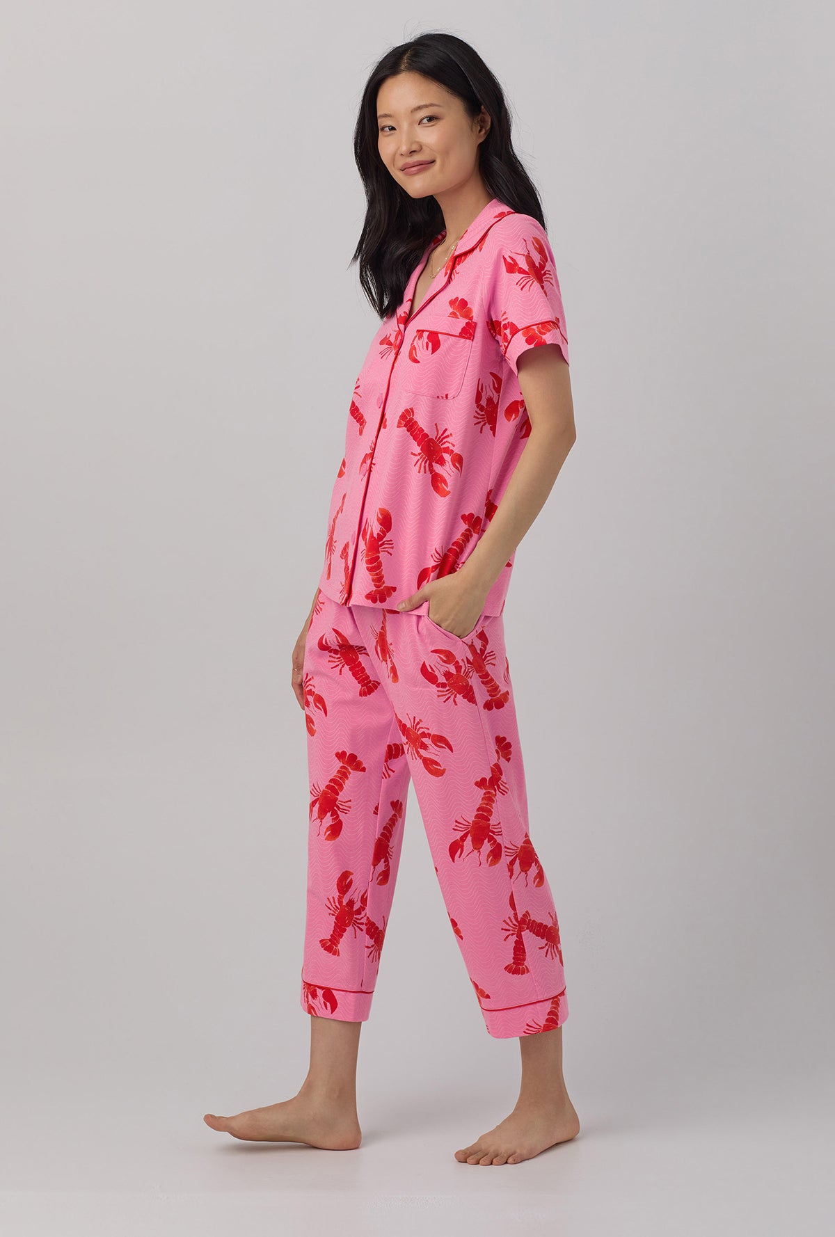 A lady wearing  pink  Short Sleeve Classic Stretch Jersey Cropped PJ Set with Lobster Fest print.