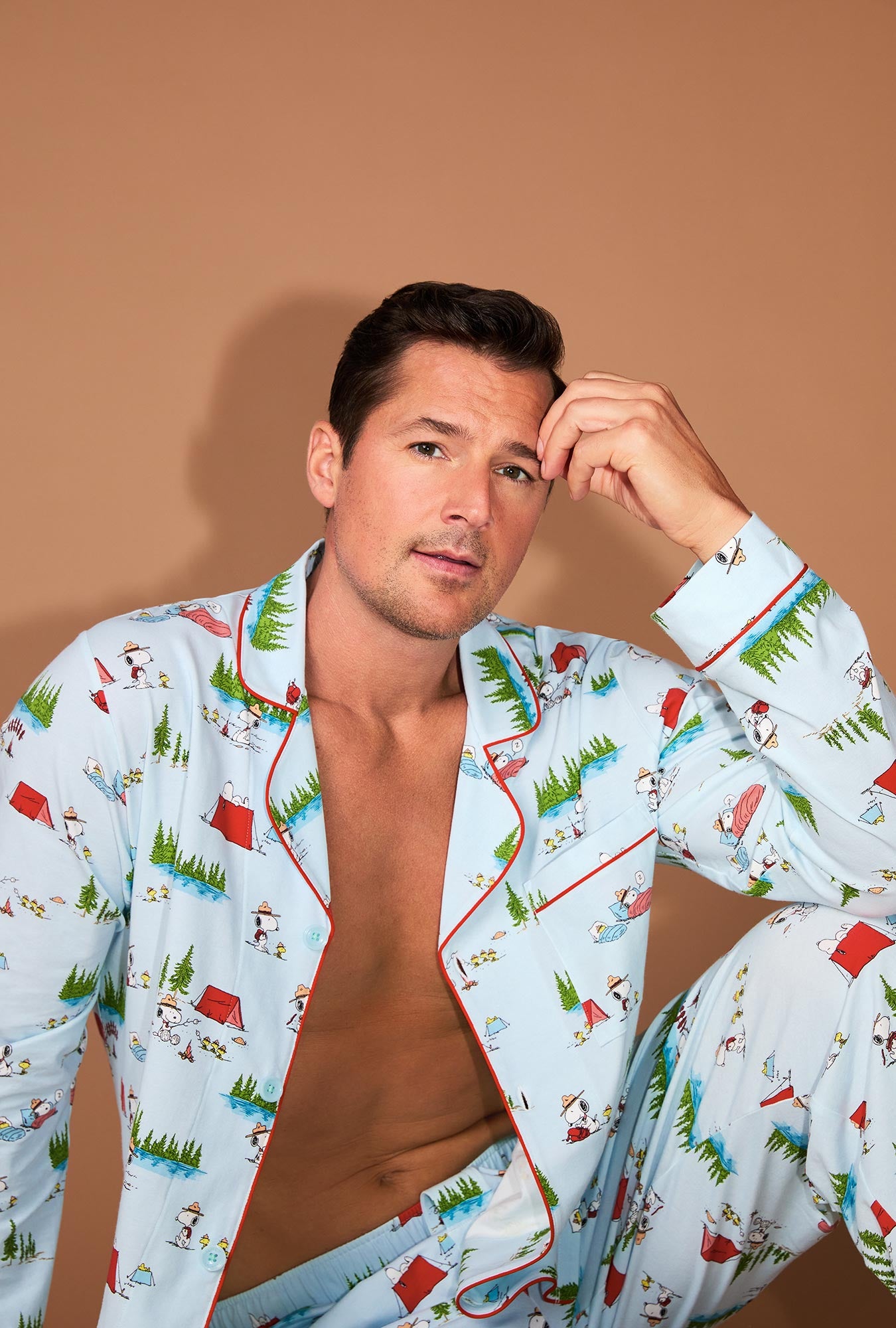 A man wearing Peanuts® Camp Snoopy Men's Long Sleeve Classic Stretch Jersey PJ Set