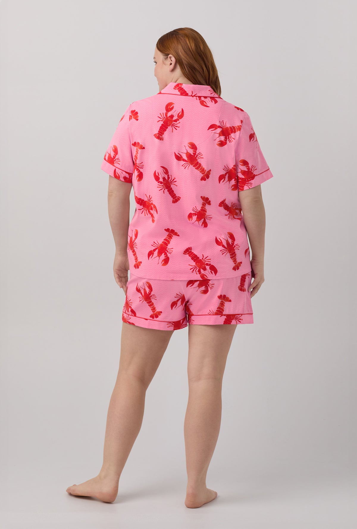 A lady wearing plus size pink  Short Sleeve Classic Shorty Stretch Jersey plus size PJ Set with Lobster Fest print.