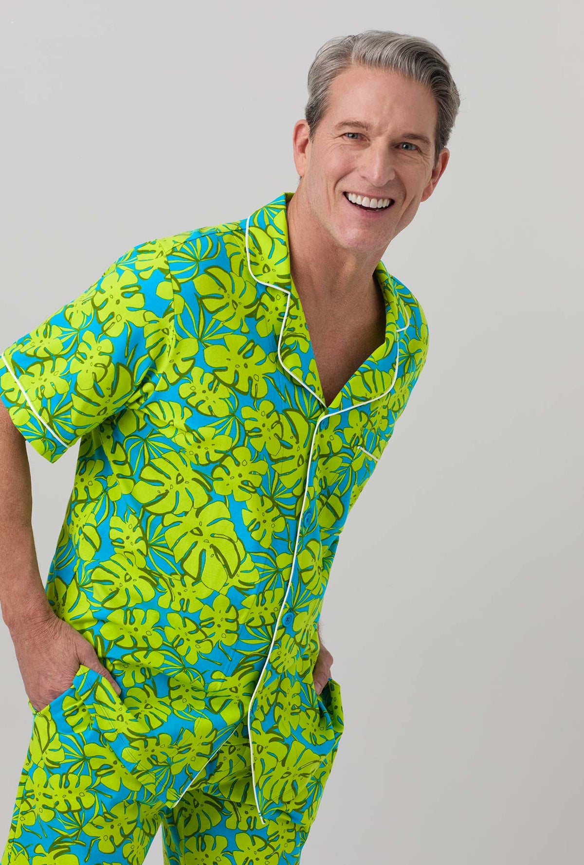 A man wearing Short Sleeve Notch Stretch Jersey Short PJ Set with palm leaves print