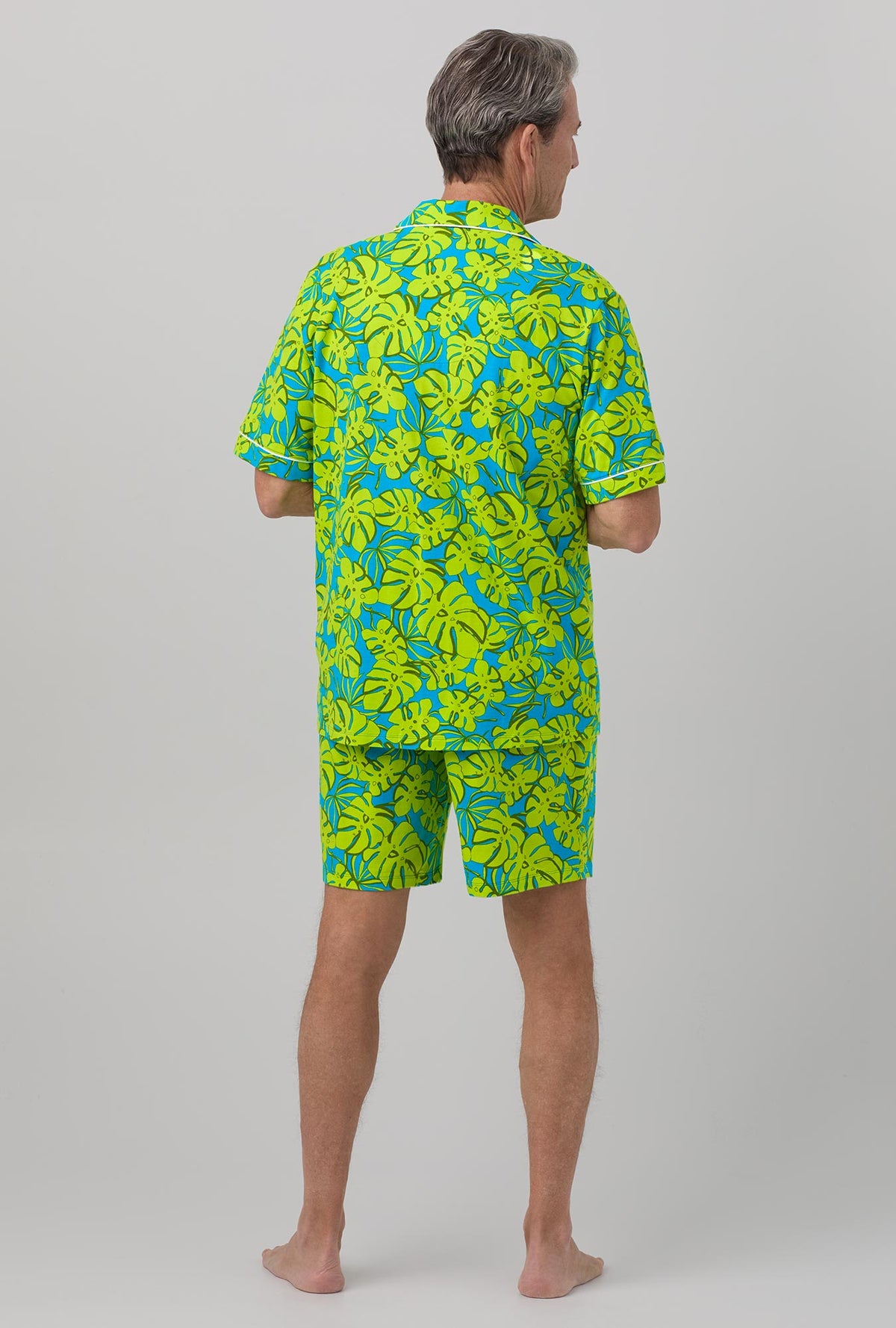 A man wearing Short Sleeve Notch Stretch Jersey Short PJ Set with palm leaves print