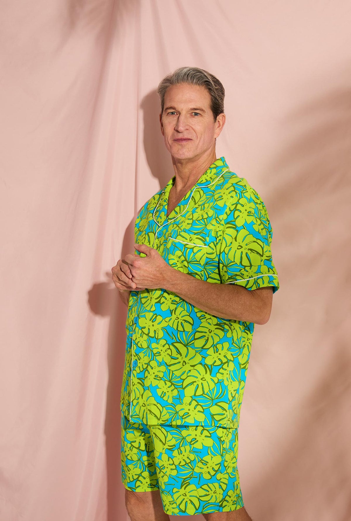 A man wearing Short Sleeve Notch Stretch Jersey Short PJ Set with palm leaves print