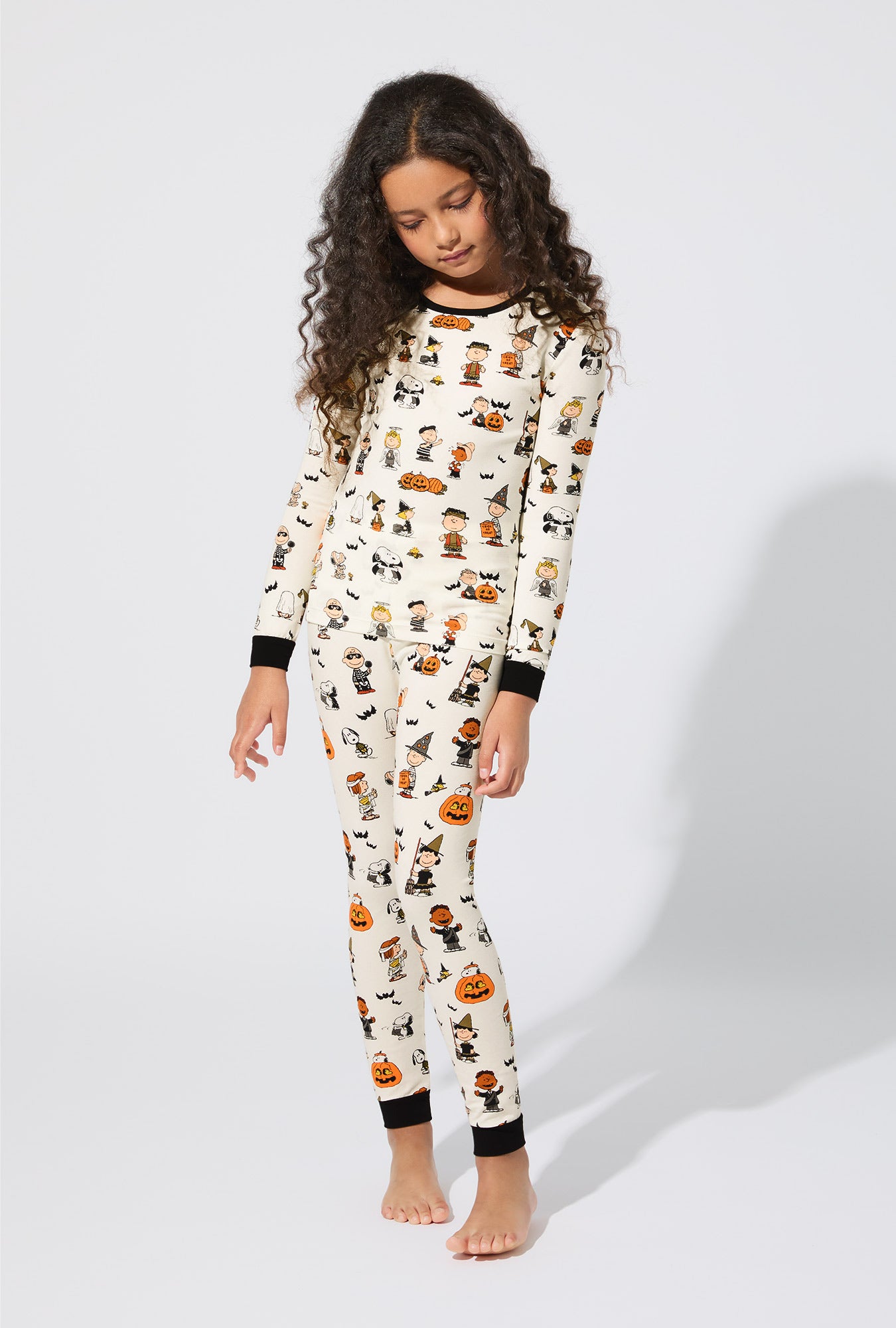 A girl wearing Peanuts® Snoopy's Halloween Long Sleeve Stretch Jersey Kids PJ Set