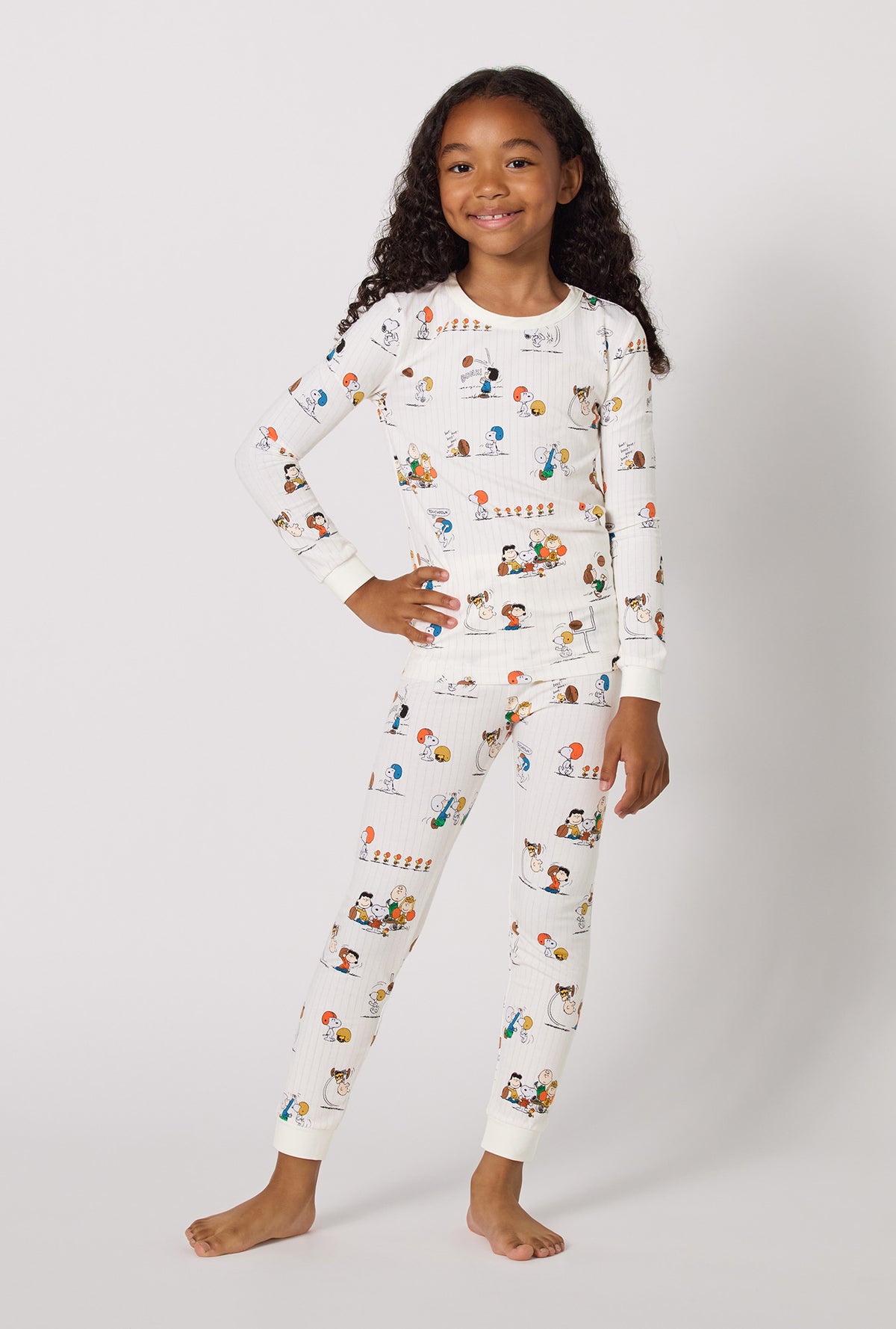 A Girl Wearing Snoopy's Game Day Long Sleeve Stretch Jersey Kids Pj Set