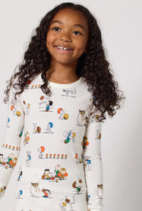 A Girl Wearing Snoopy's Game Day Long Sleeve Stretch Jersey Kids Pj Set in a close up view pose