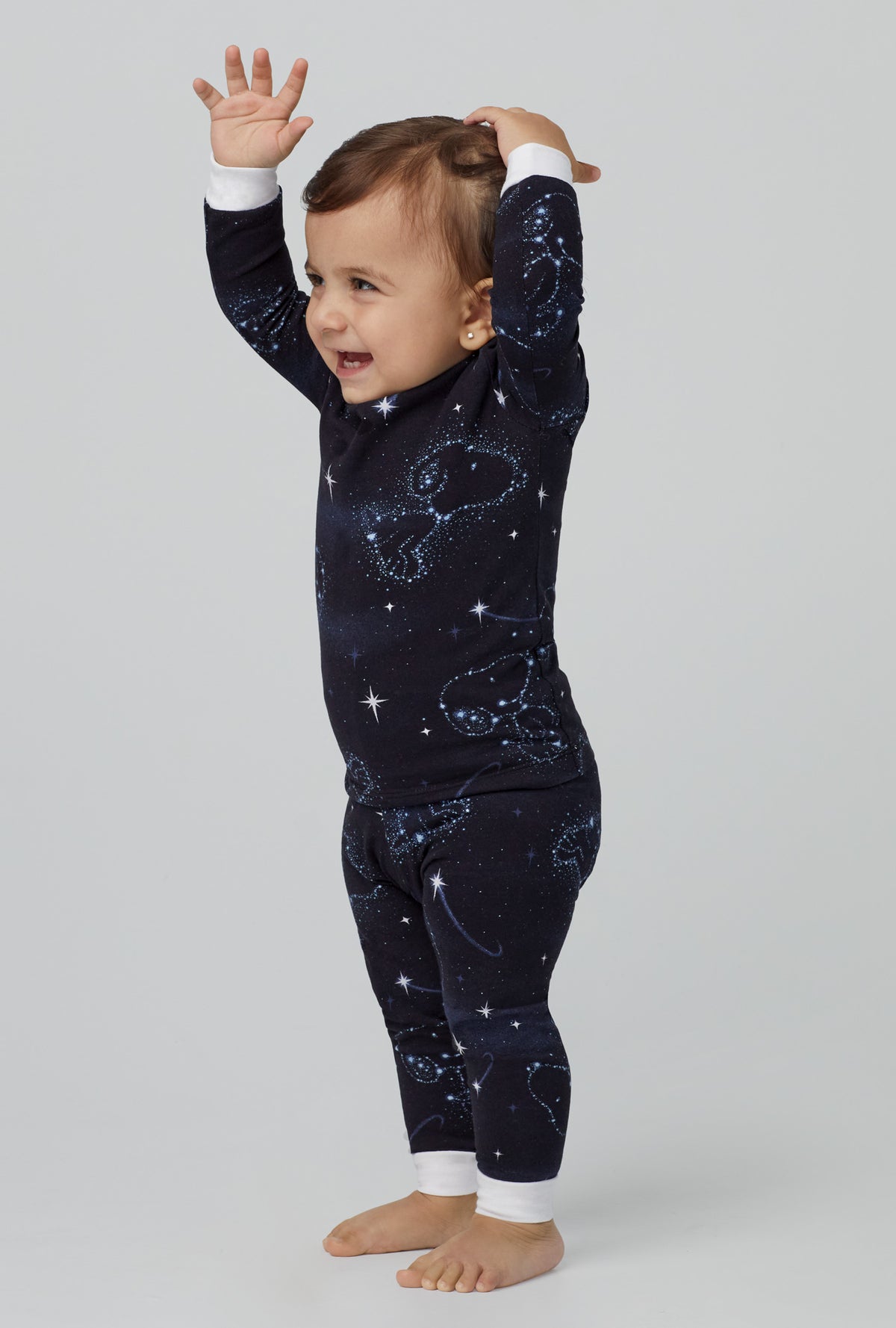 A baby wearing black long sleeve stretch jersey boo boo pj set with celestial snoopy print.