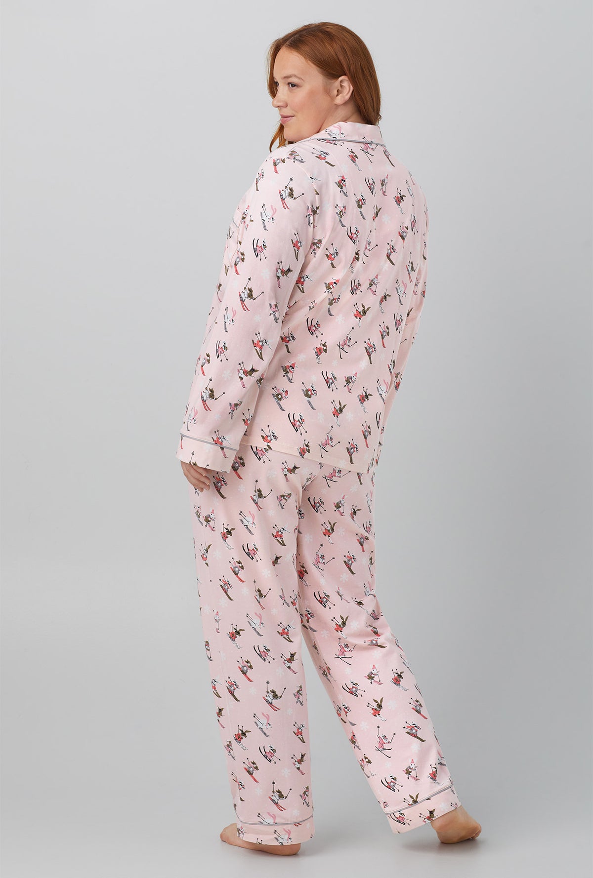A lady wearing pink long sleeve classic stretch jersey plus pj set with ski bunnies print.