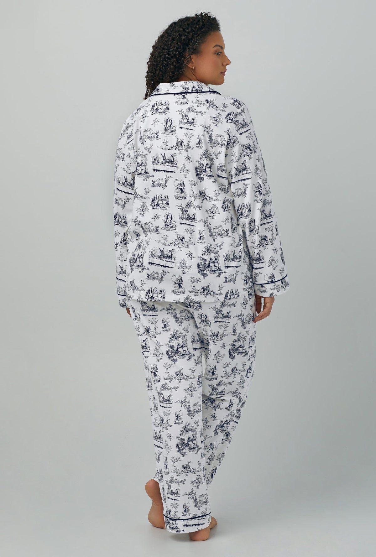 A lady wearing plus size white Long Sleeve Classic Stretch Jersey PJ Set with Adventures in Wonderland print