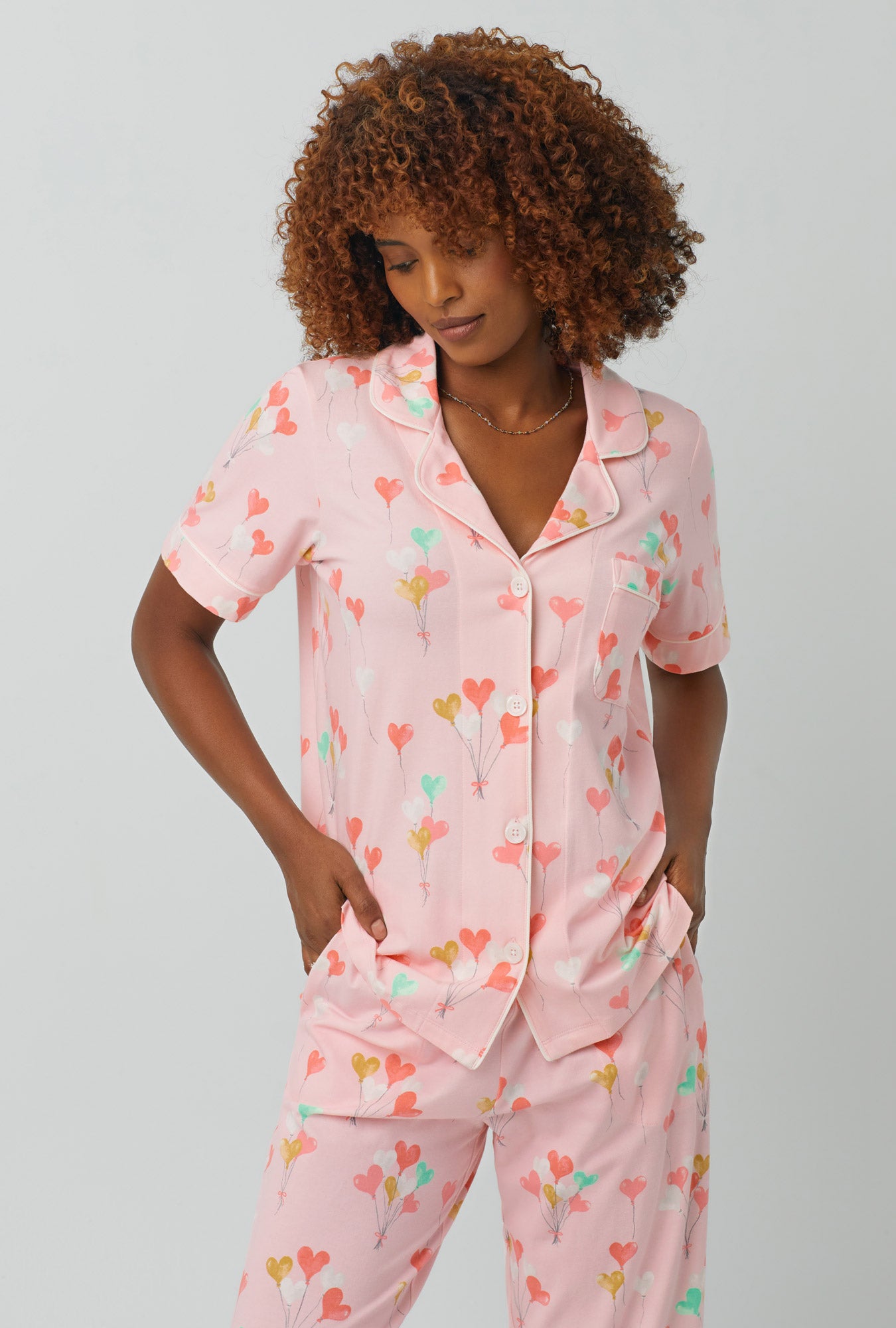 A lady wearing Short Sleeve Classic Stretch Jersey Cropped PJ Set with floating hearts print