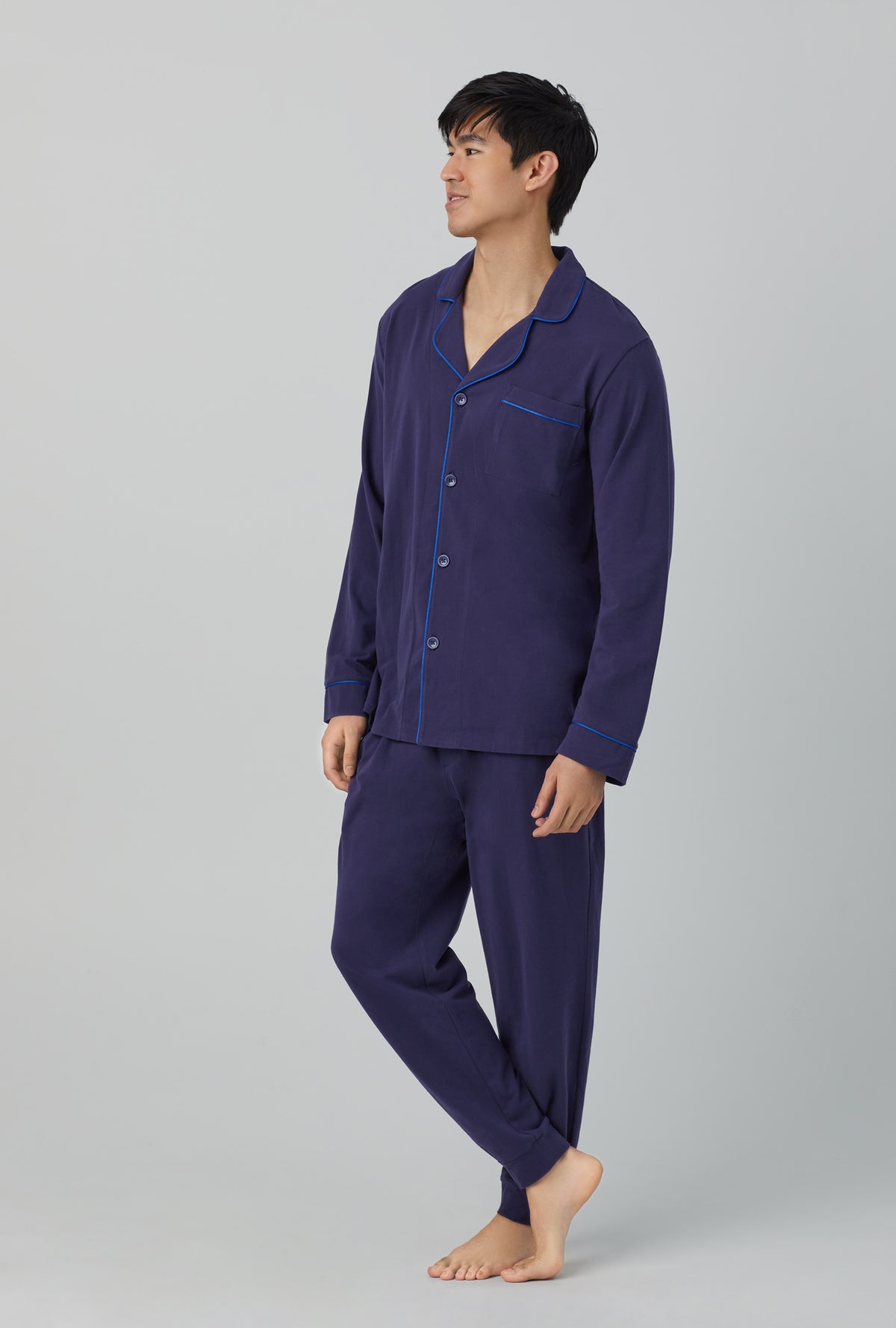 A man wearing navy long sleeve and jogger stretch jersey pj set.