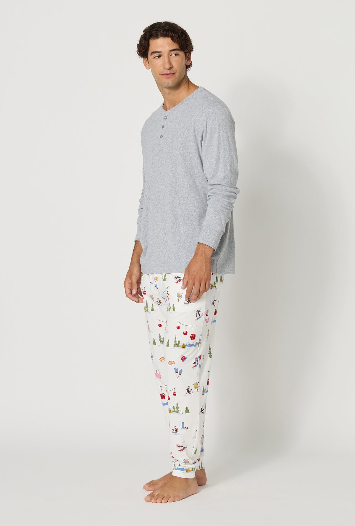 A man wearing Snow Much Fun Men's Long Sleeve Henley And Jogger Stretch Jersey Pj Set looking side