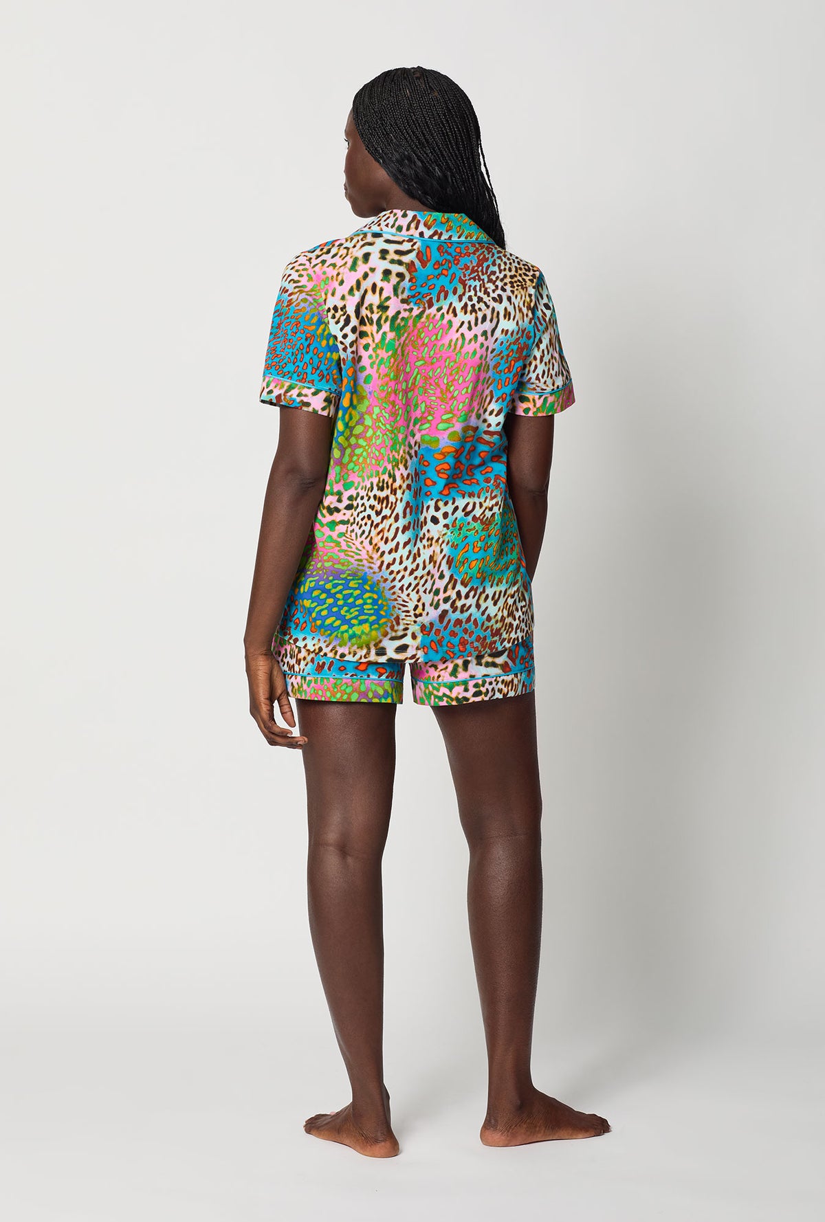 A lady wearing BedHead x Trina Turk Spray Leopard Short Sleeve Classic Shorty Stretch Jersey Pj Set