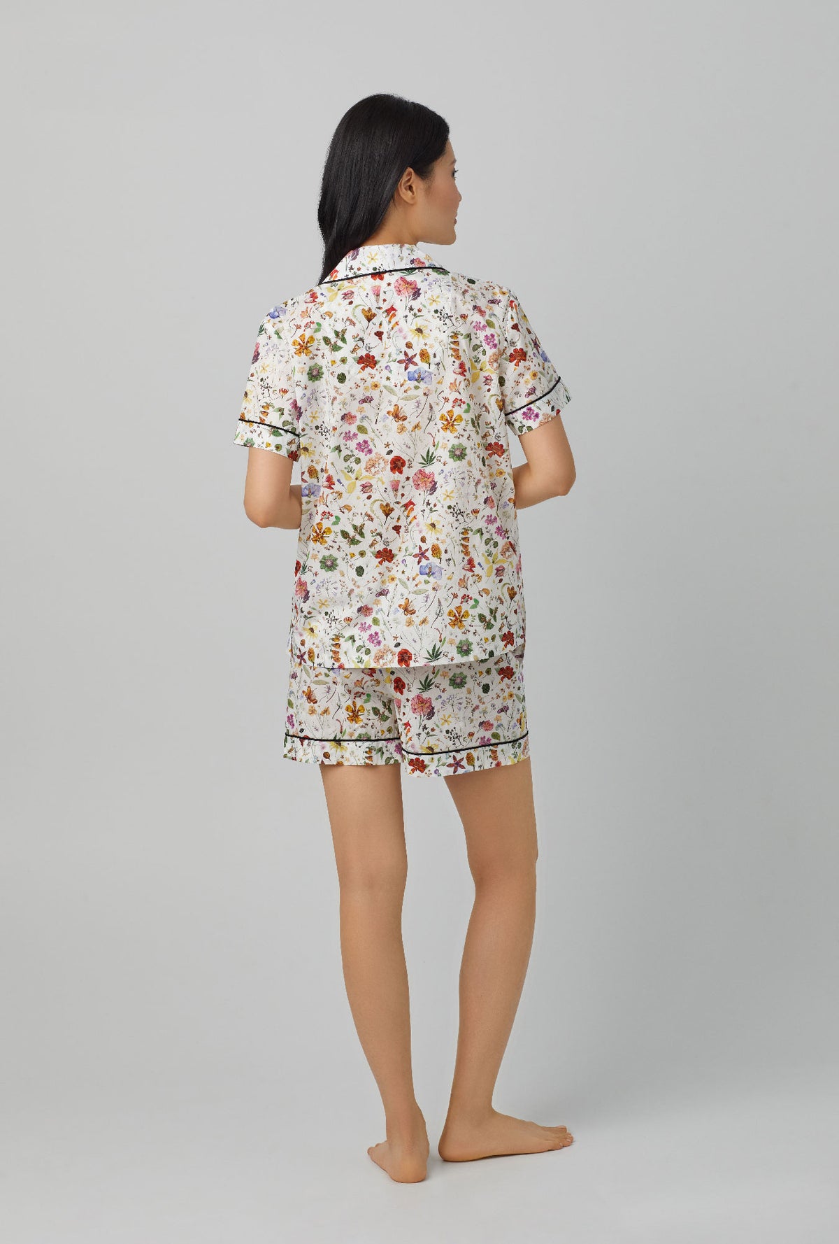A lady wearing short sleeve classic short pj set with floral eve print