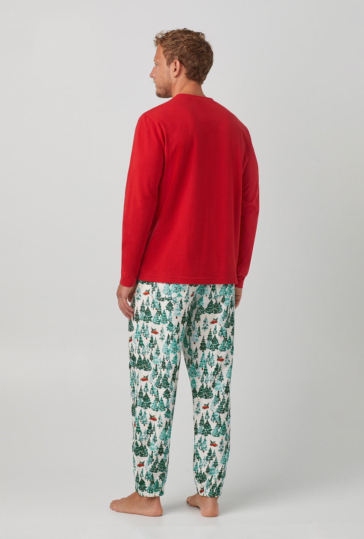A man wearing red  Jogger Woven Cotton Portuguese Flannel PJ Set with Winter Forest print