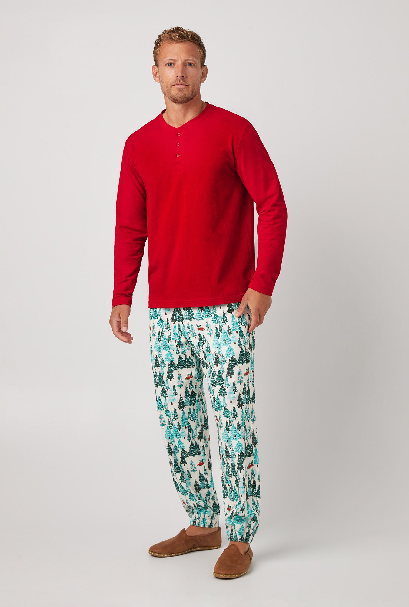 A man wearing red  Jogger Woven Cotton Portuguese Flannel PJ Set with Winter Forest print