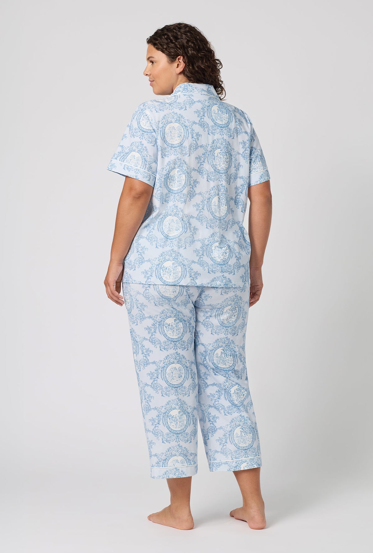 A Lady Wearing Plus Size Minuet Toile Short Sleeve Classic Stretch Jersey Cropped Pj Set in a back view pose