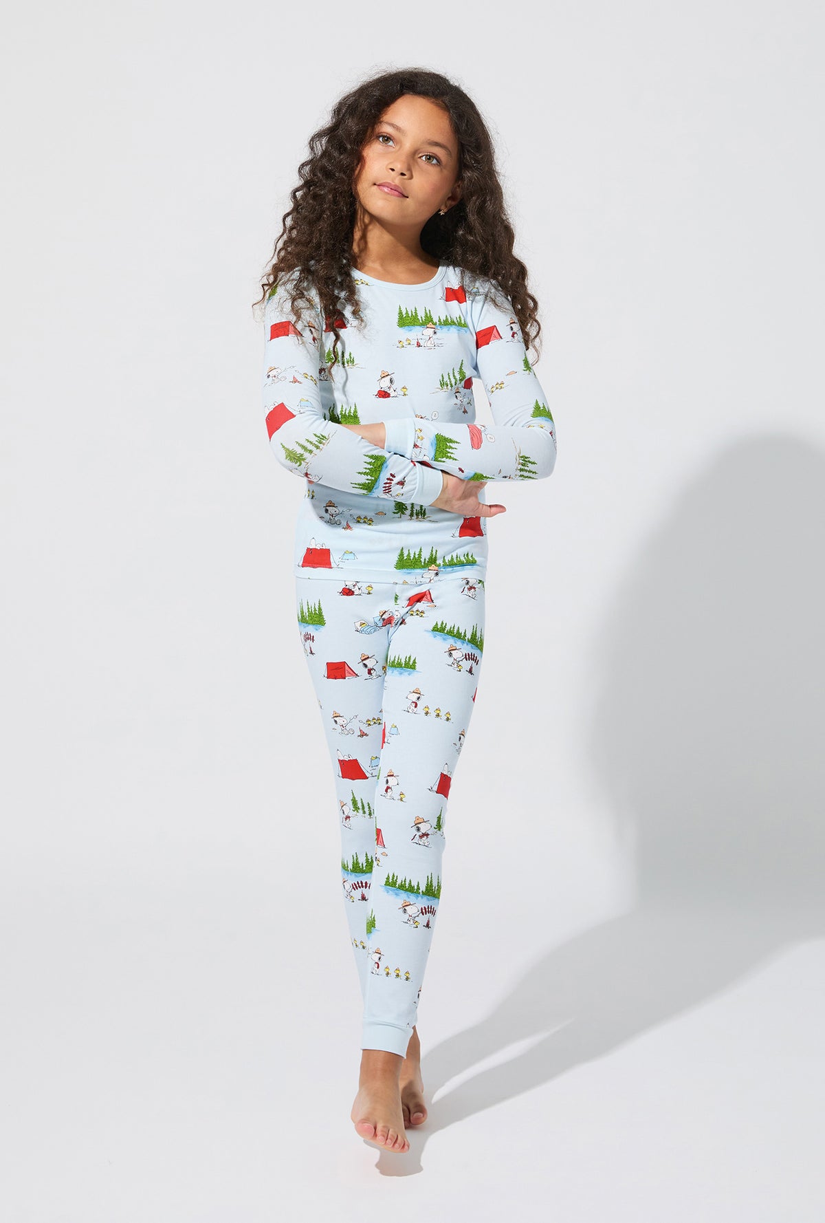 A girl wearing Peanuts® Camp Snoopy Long Sleeve Stretch Jersey Kids PJ Set