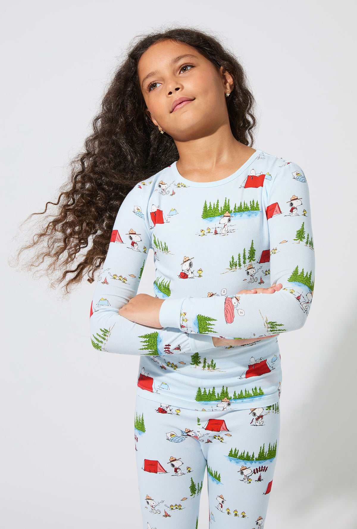 A girl wearing Peanuts® Camp Snoopy Long Sleeve Stretch Jersey Kids PJ Set