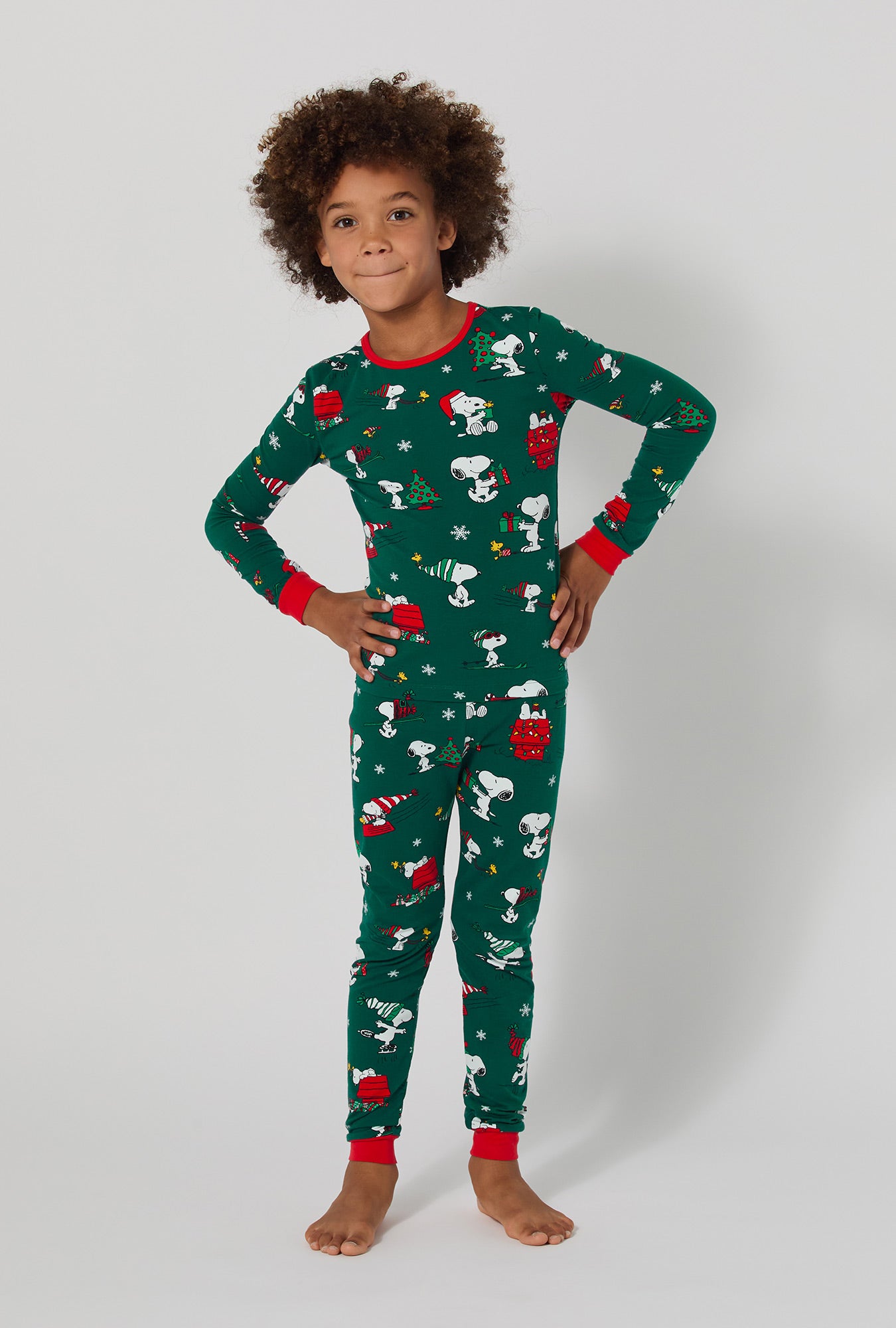 A girl wearing ®Snoopy's Holiday Fun Long Sleeve Stretch Jersey Kids Pj Set
